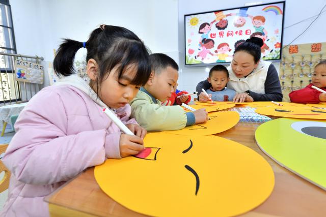 (251120) -- BEIJING, Nov. 20, 2025 (Xinhua) -- A teacher teaches children to draw smiling faces to celebrate the upcoming World Hello Day, which falls on Nov. 21 annually, at a kindergarten in Xiangyang, central China's Hubei Province, Nov. 20, 2025. (Photo by Yang Tao/Xinhua)