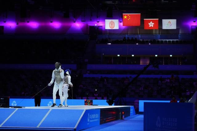 (251120) -- HONG KONG, Nov. 20, 2025 (Xinhua) -- Chen Qingyuan (L) of Fujian celebrate scoring on Huang Ali of Chongqing during the women's foil team final of fencing between Fujian and Chongqing at China's 15th National Games in Hong Kong, south China, Nov. 20, 2025. (Xinhua/Zhu Wei)