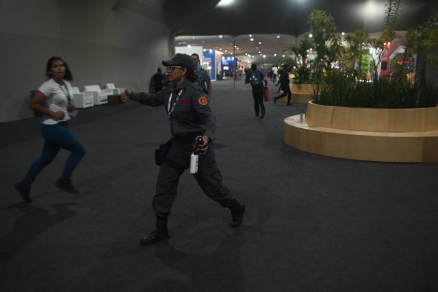 (251120) -- BELEM(BRAZIL), Nov. 20, 2025 (Xinhua) -- Security evacuate people inside the venue of the 30th United Nations Climate Change Conference (COP30) after a fire borke out in Belem, Para state, Brazil, Nov. 20, 2025. A fire broke out on Thursday in a pavilion at the ongoing 30th UN Climate Change Conference in the Brazilian city of Belem, prompting evacuations by the fire department, according to local authorities. (Photo by Lucio Tavora/Xinhua)
