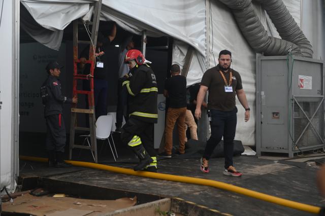 (251120) -- BELEM(BRAZIL), Nov. 20, 2025 (Xinhua) -- Firefighters and staff members inspect the venue of the 30th United Nations Climate Change Conference (COP30) after a fire borke out in Belem, Para state, Brazil, Nov. 20, 2025. A fire broke out on Thursday in a pavilion at the ongoing 30th UN Climate Change Conference in the Brazilian city of Belem, prompting evacuations by the fire department, according to local authorities. (Photo by Lucio Tavora/Xinhua)