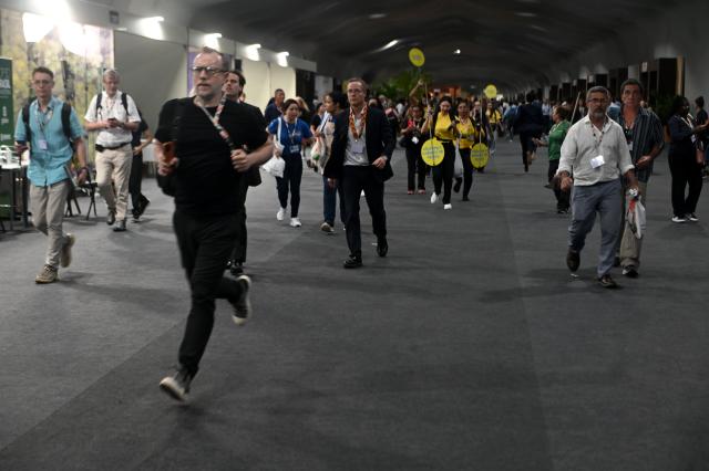 (251120) -- BELEM(BRAZIL), Nov. 20, 2025 (Xinhua) -- Participants evacuate the venue of the 30th United Nations Climate Change Conference (COP30) a fire borke out in Belem, Para state, Brazil, Nov. 20, 2025. A fire broke out on Thursday in a pavilion at the ongoing 30th UN Climate Change Conference in the Brazilian city of Belem, prompting evacuations by the fire department, according to local authorities. (Photo by Lucio Tavora/Xinhua)