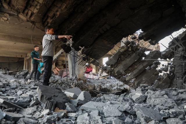 (251121) -- BEIJING, Nov. 21, 2025 (Xinhua) -- Palestinians inspect the destroyed houses after Israeli airstrikes in Al-Zeitoun neighborhood east of Gaza City, Nov. 20, 2025. (Photo by Rizek Abdeljawad/Xinhua)