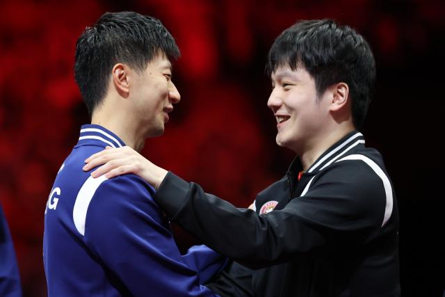 (251121) -- BEIJING, Nov. 21, 2025 (Xinhua) -- Fan Zhendong (R) of Shanghai and Ma Long of Beijing greet each other after the men's team final of table tennis between Beijing and Shanghai at China's 15th National Games in Macao, south China, Nov. 20, 2025. (Xinhua/Liu Xu)