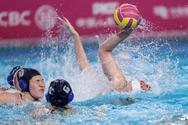 (251121) -- GUANGZHOU, Nov. 21, 2025 (Xinhua) -- Zhou Shang (R) of Hunan shoots during the women's water polo bronze medal match between Guangxi and Hunan at China's 15th National Games in Guangzhou, south China's Guangdong Province, Nov. 21, 2025. (Xinhua/Pan Yulong)