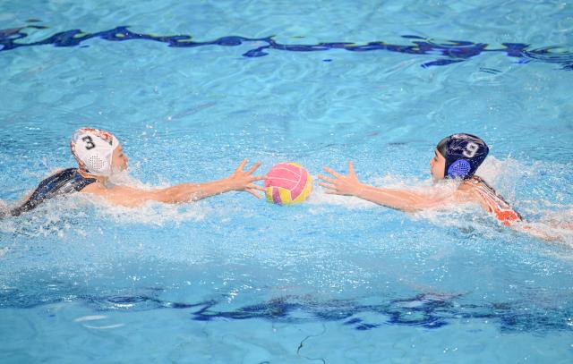 (251121) -- GUANGZHOU, Nov. 21, 2025 (Xinhua) -- Zhai Ying (L) of Hunan vies with Pan Xiuhua during the women's water polo bronze medal match between Guangxi and Hunan at China's 15th National Games in Guangzhou, south China's Guangdong Province, Nov. 21, 2025. (Xinhua/Xiao Ennan)