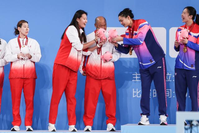 (251121) -- GUANGZHOU, Nov. 21, 2025 (Xinhua) -- Gold medalist Shen Yineng (2nd R) of Shanghai reacts with silver medalist Du Xinyue (2nd L) of Tianjin during the awarding ceremony for the women's water polo at China's 15th National Games in Guangzhou, south China's Guangdong Province, Nov. 21, 2025. (Xinhua/Pan Yulong)