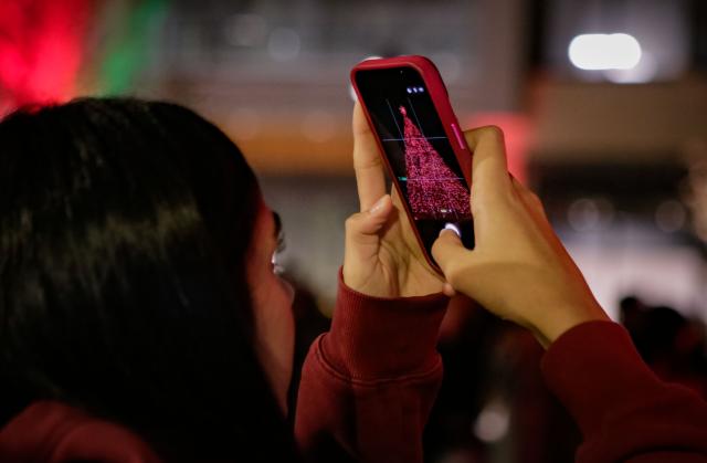 (251121) -- RICHMOND, Nov. 21, 2025 (Xinhua) -- A woman takes photos of the Christmas tree during a Christmas tree lighting ceremony at Richmond Centre Plaza in Richmond, British Columbia, Canada, Nov. 20, 2025.
  The 78-foot-tall Christmas tree is illuminated during the ceremony here on Thursday, marking the start of the festive season. (Photo by Liang Sen/Xinhua)