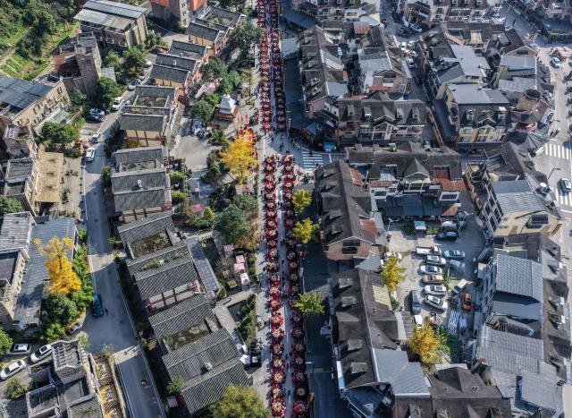 (251121) -- WENCHUAN, Nov. 21, 2025 (Xinhua) -- An aerial drone photo taken on Nov. 20, 2025 shows residents attending a group banquet in celebration of the Qiang New Year in Wenchuan County, Aba Tibetan and Qiang Autonomous Prefecture, southwest China's Sichuan Province. An event celebrating the Qiang New Year was held here from Wednesday to Thursday, featuring a series of activities. (Photo by Li Xiangyu/Xinhua)