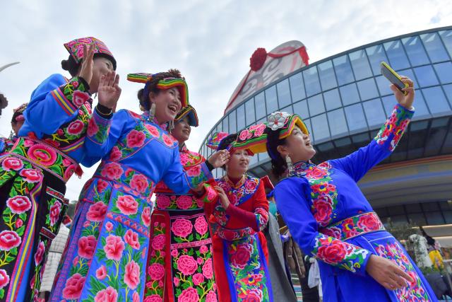 (251121) -- WENCHUAN, Nov. 21, 2025 (Xinhua) -- Women in ethnic attire take a selfie during an event celebrating the Qiang New Year in Wenchuan County, Aba Tibetan and Qiang Autonomous Prefecture, southwest China's Sichuan Province, Nov. 20, 2025. An event celebrating the Qiang New Year was held here from Wednesday to Thursday, featuring a series of activities. (Photo by Li Xiangyu/Xinhua)