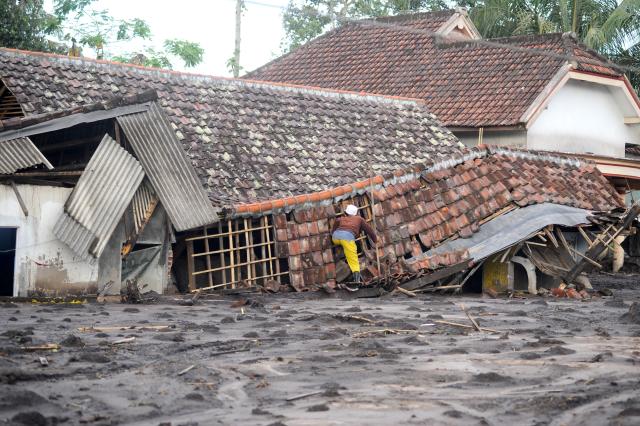 (251121) -- LUMAJANG, Nov. 21, 2025 (Xinhua) -- A man checks his damaged house following the eruption of the Semeru volcano at Sapiturang village in Lumajang regency, East Java, Indonesia, Nov. 20, 2025. Indonesia's Semeru volcano erupted on Wednesday, prompting the country's volcanology agency to raise the alert level to the maximum. (Photo by Sahlan Kurniawan/Xinhua)