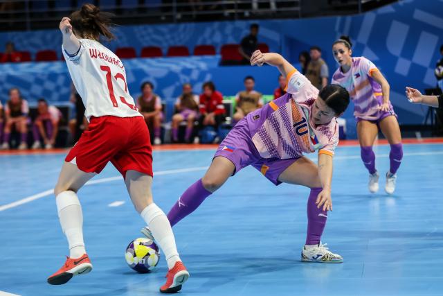 (251122) -- PASIG CITY, Nov. 22, 2025 (Xinhua) -- Katarzyna Wlodarczyk (L) of Poland vies against Judy Connolly (C) of the Philippines during the match between Poland and the Philippines at the FIFA Futsal Women's World Cup 2025 in Pasig City, the Philippines, Nov. 21, 2025. (Xinhua/Rouelle Umali)