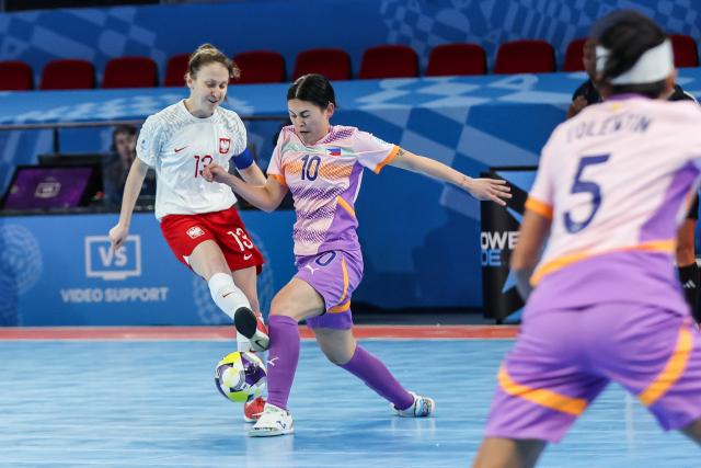 (251122) -- PASIG CITY, Nov. 22, 2025 (Xinhua) -- Katarzyna Wlodarczyk (L) of Poland vies against Judy Connolly of the Philippines during the match between Poland and the Philippines at the FIFA Futsal Women's World Cup 2025 in Pasig City, the Philippines, Nov. 21, 2025. (Xinhua/Rouelle Umali)