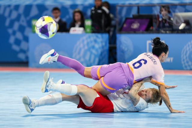 (251122) -- PASIG CITY, Nov. 22, 2025 (Xinhua) -- Klaudia Dyminska (Bottom) of Poland competes against Jaclyn Sawicki (Top) of the Philippines during the match between Poland and the Philippines at the FIFA Futsal Women's World Cup 2025 in Pasig City, the Philippines, Nov. 21, 2025. (Xinhua/Rouelle Umali)