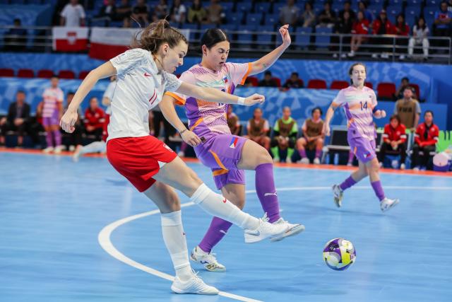 (251122) -- PASIG CITY, Nov. 22, 2025 (Xinhua) -- Wiktoria Pietrzyk (L) of Poland vies against players of the Philippines during the match between Poland and the Philippines at the FIFA Futsal Women's World Cup 2025 in Pasig City, the Philippines, Nov. 21, 2025. (Xinhua/Rouelle Umali)