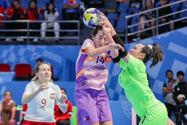 (251122) -- PASIG CITY, Nov. 22, 2025 (Xinhua) -- Goalkeeper Samantha Hughes (R) and Isabella Flanigan (C) the Philippines compete during the match between Poland and the Philippines at the FIFA Futsal Women's World Cup 2025 in Pasig City, the Philippines, Nov. 21, 2025. (Xinhua/Rouelle Umali)