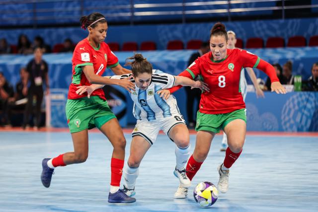 (251122) -- PASIG CITY, Nov. 22, 2025 (Xinhua) -- Melina Quevedo (C) of Argentina vies against players of Morocco during the match between Argentina and Morocco at the FIFA Futsal Women's World Cup 2025 in Pasig City, the Philippines, Nov. 21, 2025. (Xinhua/Rouelle Umali)