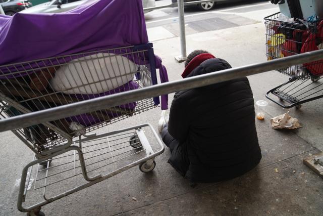 (251122) -- NEW YORK, Nov. 22, 2025 (Xinhua) -- A man with his luggage sits by a street near a shelter for the homeless in New York, the United States, on Nov. 21, 2025. It is estimated that more than 350,000 people were without home in New York City (NYC) by August this year, the highest level since the Great Depression of the 1930s, according to the Coalition for the Homeless. Most of them slept in NYC shelters or temporarily doubled-up in the homes of others, and thousands slept unsheltered on streets, parks and subways. (Xinhua/Zhang Fengguo)