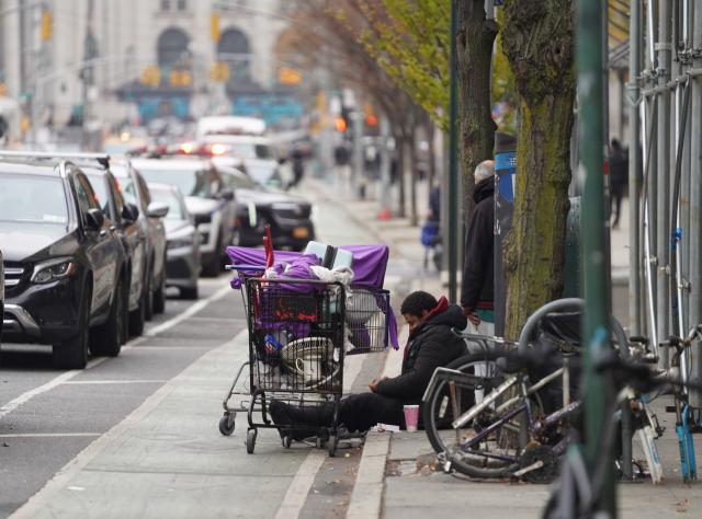(251122) -- NEW YORK, Nov. 22, 2025 (Xinhua) -- A man with his luggage sits by a street near a shelter for the homeless in New York, the United States, on Nov. 21, 2025. It is estimated that more than 350,000 people were without home in New York City (NYC) by August this year, the highest level since the Great Depression of the 1930s, according to the Coalition for the Homeless. Most of them slept in NYC shelters or temporarily doubled-up in the homes of others, and thousands slept unsheltered on streets, parks and subways. (Xinhua/Zhang Fengguo)