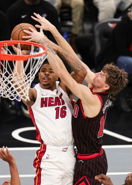 (251122) -- CHICAGO, Nov. 22, 2025 (Xinhua) -- Keshad Johnson (L) of Miami Heat shoots the ball against Matas Buzelis of Chicago Bulls during the 2025-2026 NBA Cup group match between Chicago Bulls and Miami Heat in Chicago, the United States, on Nov. 21, 2025. (Photo by Joel Lerner/Xinhua)