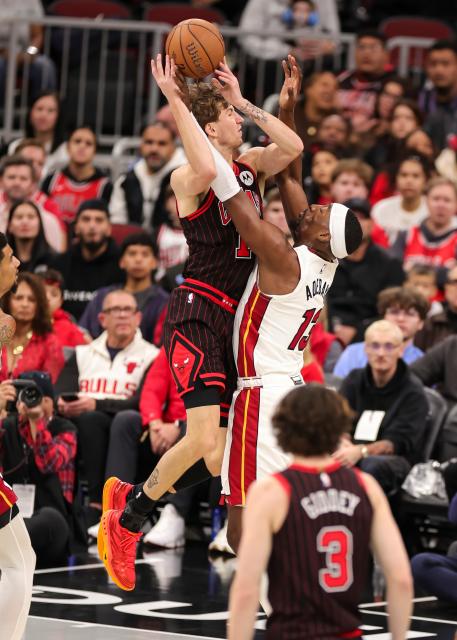 (251122) -- CHICAGO, Nov. 22, 2025 (Xinhua) -- Matas Buzelis (top) of Chicago Bulls goes to the basket against Bam Adebayo of Miami Heat during the 2025-2026 NBA Cup group match between Chicago Bulls and Miami Heat in Chicago, the United States, on Nov. 21, 2025. (Photo by Joel Lerner/Xinhua)