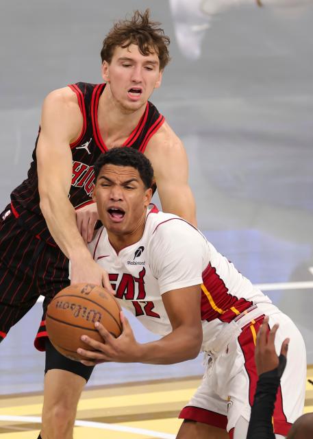 (251122) -- CHICAGO, Nov. 22, 2025 (Xinhua) -- Matas Buzelis (top) of Chicago Bulls vies with Dru Smith of Miami Heat during the 2025-2026 NBA Cup group match between Chicago Bulls and Miami Heat in Chicago, the United States, on Nov. 21, 2025. (Photo by Joel Lerner/Xinhua)