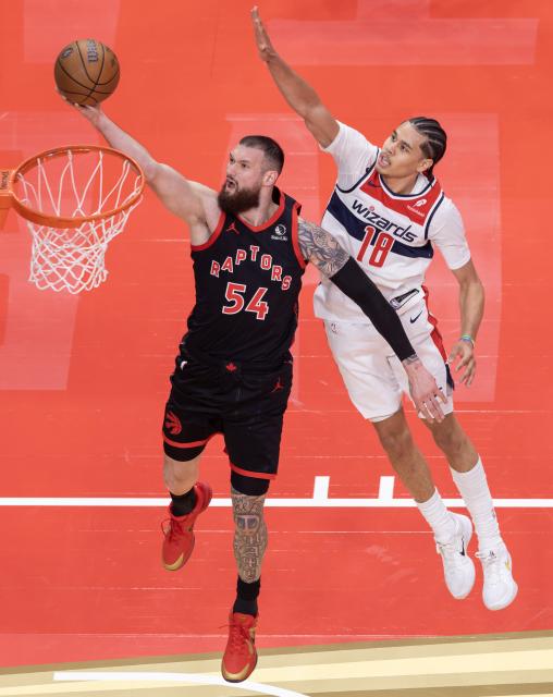 (251122) -- TORONTO, Nov. 22, 2025 (Xinhua) -- Sandro Mamukelashvili (L) of Toronto Raptors goes up for a layup during the 2025-2026 NBA Cup group match between Toronto Raptors and Washington Wizards in Toronto, Canada, Nov. 21, 2025. (Photo by Zou Zheng/Xinhua)