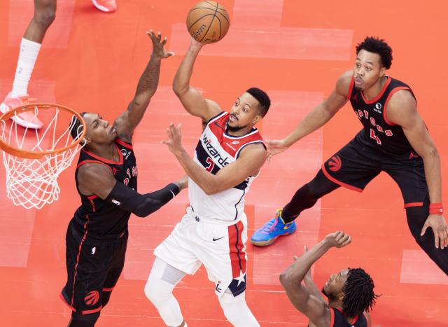 (251122) -- TORONTO, Nov. 22, 2025 (Xinhua) -- CJ McCollum (C) of Washington Wizards goes up for a layup as RJ Barrett (L) of Toronto Raptors defends during the 2025-2026 NBA Cup group match between Toronto Raptors and Washington Wizards in Toronto, Canada, Nov. 21, 2025. (Photo by Zou Zheng/Xinhua)