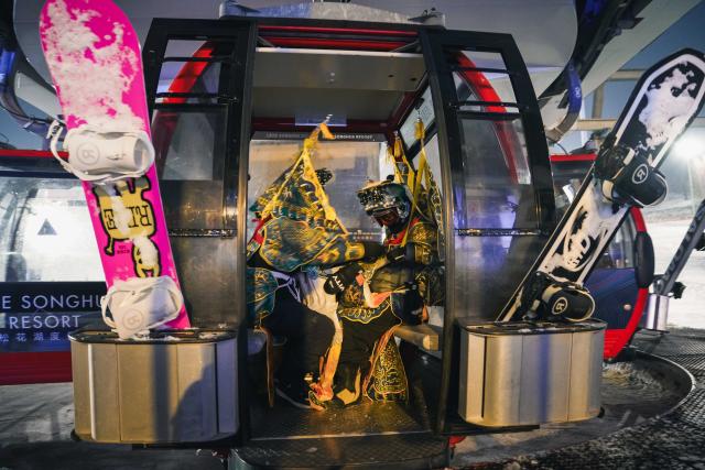 (251122) -- JILIN, Nov. 22, 2025 (Xinhua) -- Skiers dressed up in Peking Opera costumes take a cable car before a themed skiing show at the Lake Songhua Resort of Jilin City, northeast China's Jilin Province on Nov. 21, 2025. More than 260 skiers dressed up in Peking Opera costumes ski 1000m together to celebrate the new ski season. (Xinhua/Xu Chang)