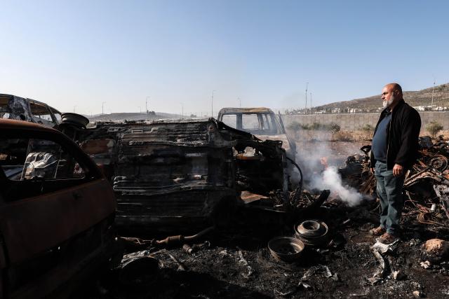 (251122) -- NABLUS, Nov. 22, 2025 (Xinhua) -- A Palestinian checks a vehicle scrapyard after Israeli settlers burned it in the town of Huwara, south of the West Bank city of Nablus, on Nov. 21, 2025. According to the official WAFA news agency, Israeli settlers set fire to a vehicle scrapyard here on Friday evening. (Photo by Ayman Nobani/Xinhua)