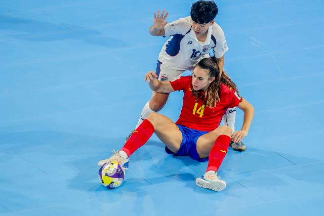 (251122) -- PASIG CITY, Nov. 22, 2025 (Xinhua) -- Irene Cordoba (Front) of Spain vies against Lalida Chimpabut (Back) of Thailand during the match between Spain and Thailand at the FIFA Futsal Women's World Cup 2025 in Pasig City, the Philippines, Nov. 22, 2025. (Xinhua/Rouelle Umali)