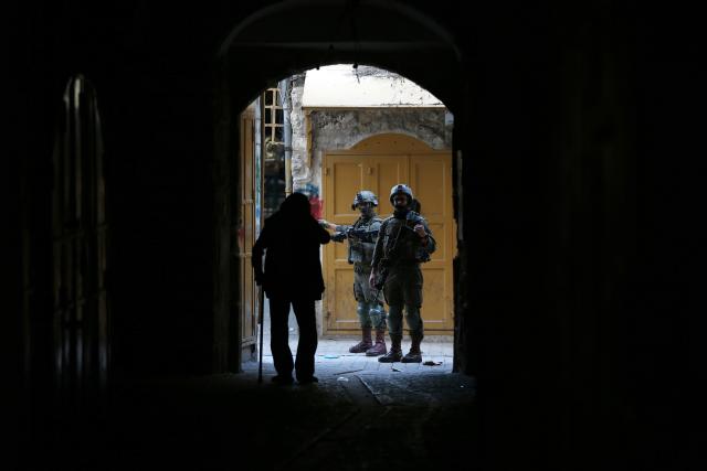 (251123) -- HEBRON, Nov. 23, 2025 (Xinhua) -- Members of Israeli forces secure the streets for Israeli settlers in the Old City of Hebron in the southern West Bank on Nov. 22, 2025. (Photo by Mamoun Wazwaz/Xinhua)