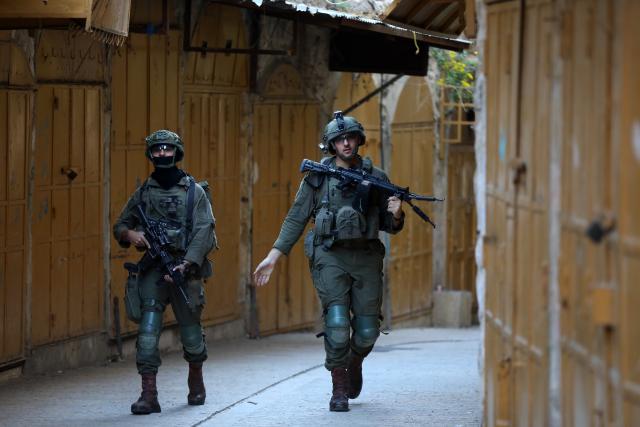 (251123) -- HEBRON, Nov. 23, 2025 (Xinhua) -- Members of Israeli forces secure the streets for Israeli settlers in the Old City of Hebron in the southern West Bank on Nov. 22, 2025. (Photo by Mamoun Wazwaz/Xinhua)