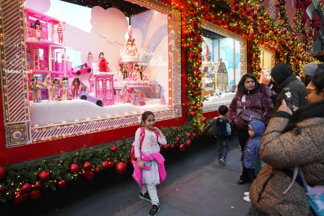 (251123) -- NEW YORK, Nov. 23, 2025 (Xinhua) -- A girl poses in front of a holiday-decorated shop window in New York, the United States, on Nov. 22, 2025. (Xinhua/Zhang Fengguo)