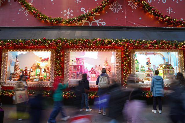 (251123) -- BEIJING, Nov. 23, 2025 (Xinhua) -- People view the holiday-decorated shop windows in New York, the United States, Nov. 22, 2025. (Xinhua/Zhang Fengguo)