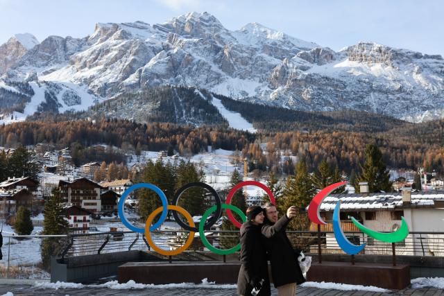 (251123) -- CORTINA D'AMPEZZO, Nov. 23, 2025 (Xinhua) -- People take a selfie in front of the emblem of Olympic and Paralympic in Cortina D'Ampezzo, Italy, Nov. 22, 2025. Located in Italy's northern region of Veneto, Cortina d'Ampezzo is famed for its beauty, ski resort and sporting legacy, beginning with the 1956 Olympic Winter Games and carrying through to Milan-Cortina 2026. (Xinhua/Li Jing)