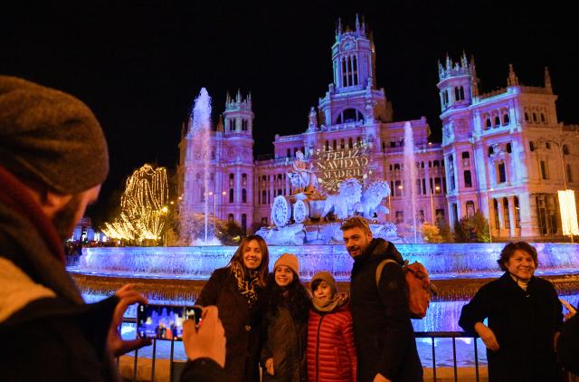 (251123) -- MADRID, Nov. 23, 2025 (Xinhua) -- People pose for a group photo in front of the Cibeles Palace in Madrid, Spain, Nov. 22, 2025.
  Madrid held a Christmas light-up ceremony on Saturday with a projection light show. (Xinhua/Cheng Min)