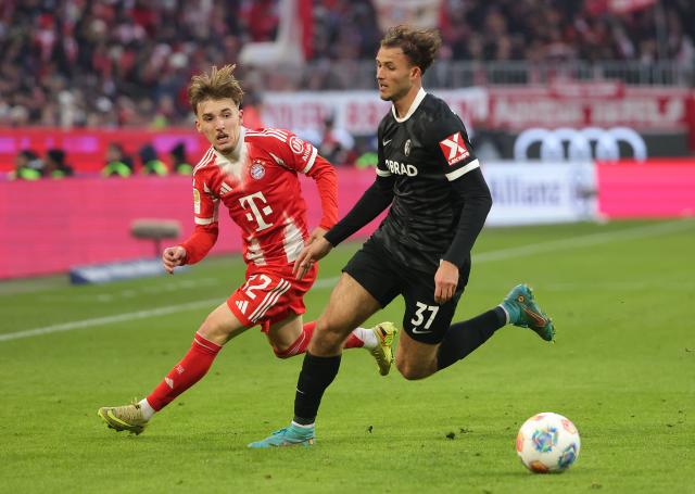(251123) -- MUNICH, Nov. 23, 2025 (Xinhua) -- Lennart Karl (L) of Bayern Munich vies with Max Rosenfelder of SC Freiburg during the German first division Bundesliga football match between Bayern Munich and SC Freiburg in Munich, Germany, Nov. 22, 2025. (Photo by Philippe Ruiz/Xinhua)