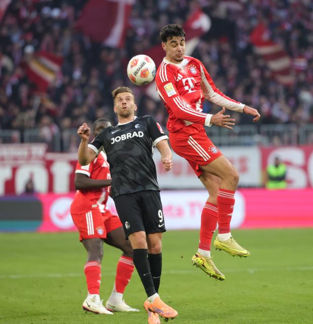 (251123) -- MUNICH, Nov. 23, 2025 (Xinhua) -- Aleksandar Pavlovic (R) of Bayern Munich and Lucas Holer of SC Freiburg head for the ball during the German first division Bundesliga football match between Bayern Munich and SC Freiburg in Munich, Germany, Nov. 22, 2025. (Photo by Philippe Ruiz/Xinhua)