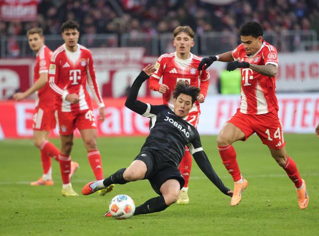 (251123) -- MUNICH, Nov. 23, 2025 (Xinhua) -- Luis Diaz (1st R) of Bayern Munich vies with Suzuki Yuito of SC Freiburg during the German first division Bundesliga football match between Bayern Munich and SC Freiburg in Munich, Germany, Nov. 22, 2025. (Photo by Philippe Ruiz/Xinhua)