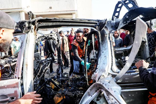 (251123) -- GAZA, Nov. 23, 2025 (Xinhua) -- Palestinians gather around a destroyed vehicle in west of Gaza City, on Nov. 22, 2025. Gaza's Civil Defense said on Saturday that Israel launched a series of airstrikes on the Gaza Strip, resulting in at least 22 deaths and dozens of injuries in the enclave.
   A Hamas source, speaking on condition of anonymity, told Xinhua that the movement has informed regional mediators of its "anger" over continued Israeli attacks on the Gaza Strip, despite Hamas and other Palestinian factions adhering to the ceasefire agreement. (Photo by Rizek Abdeljawad/Xinhua)