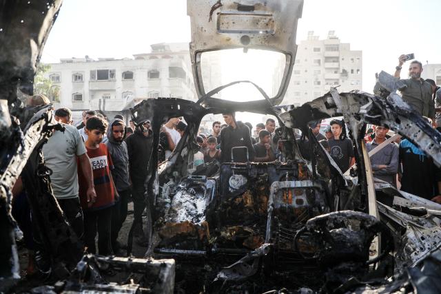 (251123) -- GAZA, Nov. 23, 2025 (Xinhua) -- Palestinians gather around a destroyed vehicle in west of Gaza City, on Nov. 22, 2025. Gaza's Civil Defense said on Saturday that Israel launched a series of airstrikes on the Gaza Strip, resulting in at least 22 deaths and dozens of injuries in the enclave.
   A Hamas source, speaking on condition of anonymity, told Xinhua that the movement has informed regional mediators of its "anger" over continued Israeli attacks on the Gaza Strip, despite Hamas and other Palestinian factions adhering to the ceasefire agreement. (Photo by Rizek Abdeljawad/Xinhua)