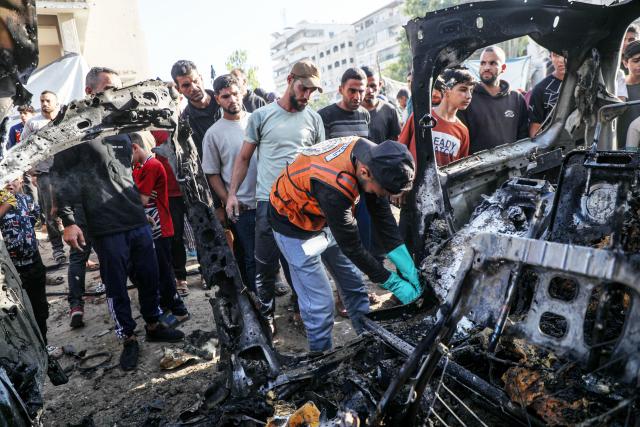 (251123) -- GAZA, Nov. 23, 2025 (Xinhua) -- Palestinians gather around a destroyed vehicle in west of Gaza City, on Nov. 22, 2025. Gaza's Civil Defense said on Saturday that Israel launched a series of airstrikes on the Gaza Strip, resulting in at least 22 deaths and dozens of injuries in the enclave.
   A Hamas source, speaking on condition of anonymity, told Xinhua that the movement has informed regional mediators of its "anger" over continued Israeli attacks on the Gaza Strip, despite Hamas and other Palestinian factions adhering to the ceasefire agreement. (Photo by Rizek Abdeljawad/Xinhua)