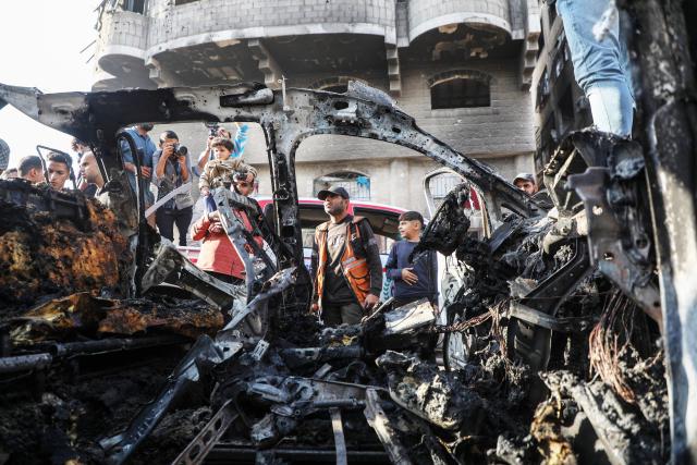 (251123) -- GAZA, Nov. 23, 2025 (Xinhua) -- Palestinians gather around a destroyed vehicle in west of Gaza City, on Nov. 22, 2025. Gaza's Civil Defense said on Saturday that Israel launched a series of airstrikes on the Gaza Strip, resulting in at least 22 deaths and dozens of injuries in the enclave.
   A Hamas source, speaking on condition of anonymity, told Xinhua that the movement has informed regional mediators of its "anger" over continued Israeli attacks on the Gaza Strip, despite Hamas and other Palestinian factions adhering to the ceasefire agreement. (Photo by Rizek Abdeljawad/Xinhua)