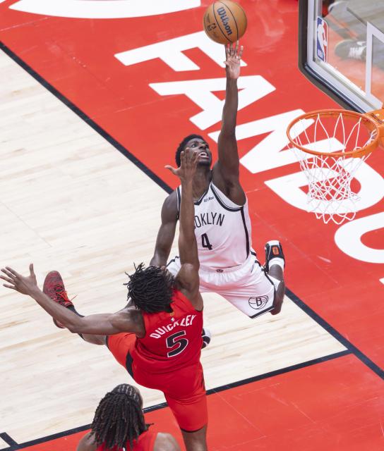 (251124) -- TORONTO, Nov. 24, 2025 (Xinhua) -- Drake Powell (top) of Brooklyn Nets goes up for a layup during the 2025-2026 NBA regular season game between Toronto Raptors and Brooklyn Nets in Toronto, Canada, on Nov. 23, 2025. (Photo by Zou Zheng/Xinhua)