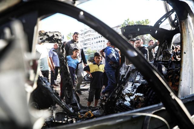 (251124) -- BEIJING, Nov. 24, 2025 (Xinhua) -- Palestinians gather around a destroyed vehicle in west of Gaza City, on Nov. 22, 2025. Gaza's Civil Defense said on Saturday that Israel launched a series of airstrikes on the Gaza Strip, resulting in at least 22 deaths and dozens of injuries in the enclave. (Photo by Rizek Abdeljawad/Xinhua)