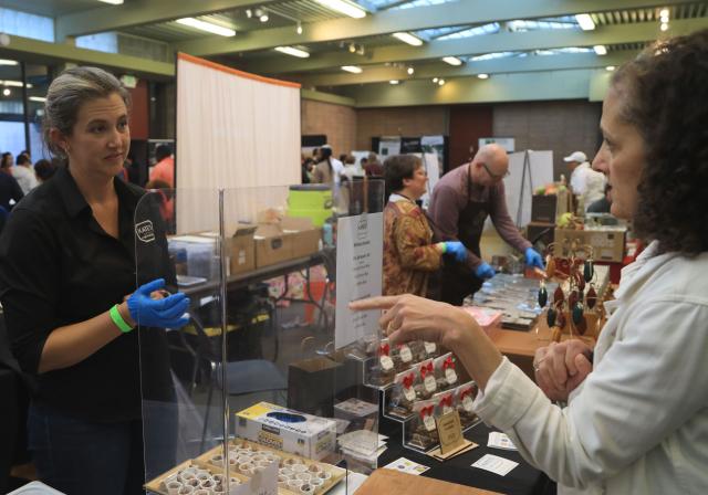 (251124) -- SAN FRANCISCO, Nov. 24, 2025 (Xinhua) -- A staff member (L) talks with a woman during the Chocolate Salon and Festival at Golden Gate Park in San Francisco, the United States, Nov. 23, 2025. (Photo by Liu Yilin/Xinhua)