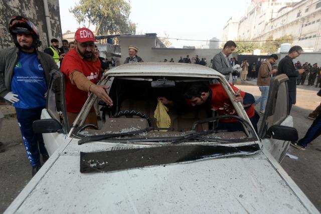 (251124) -- PESHAWAR, Nov. 24, 2025 (Xinhua) -- Rescuers inspect a damaged vehicle at the blast site in Peshawar, northwest Pakistan, on Nov. 24, 2025. At least three security personnel were killed and five others injured on Monday morning in an attack at the Federal Constabulary's headquarters in Pakistan's northwest Khyber Pakhtunkhwa provincial capital of Peshawar, police said. (Photo by Umar Qayyum/Xinhua)