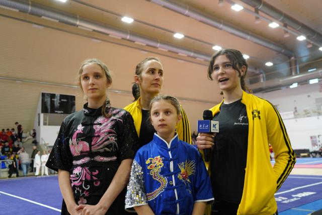 (251124) -- FOT, Nov. 24, 2025 (Xinhua) -- Anna-Maria Arutyunjan (R back) talks during an interview at the 2025 Hungarian Wushu Championships in Fot, a small town in the Budapest region, Hungary, on Nov. 22, 2025. TO GO WITH "Wushu passion sweeps Budapest at Hungarian Championships" (Xinhua/Chen Hao)