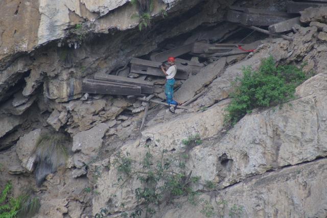 (251124) -- KUNMING, Nov. 24, 2025 (Xinhua) -- This file photo shows an archaeologist taking photos of the hanging coffin remains found in Zhaotong, southwest China's Yunnan Province. TO GO WITH "Genomic study links China's ancient hanging coffins to modern community" (Xinhua)