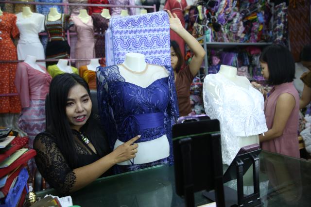 (251124) -- YANGON, Nov. 24, 2025 (Xinhua) -- A livestream seller promotes a set of clothes during a TikTok livestream in Yangon, Myanmar, Nov. 24, 2025. TO GO WITH "Feature: Myanmar's livestream sellers thrive in TikTok's booming marketplace" (Xinhua/Myo Kyaw Soe)